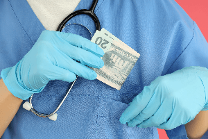 medical staff putting money in pocket