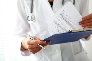 Healthcare provider holding medical documents. 